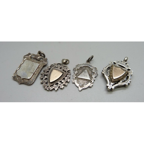 1061 - Four silver fobs, two with applied gold fronts, 58g