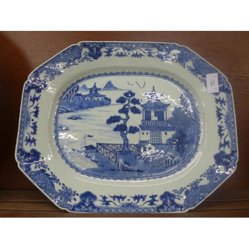 610 - An oriental blue and white plate, chip to the rim and  large blue and white Willow pattern meat plat... 