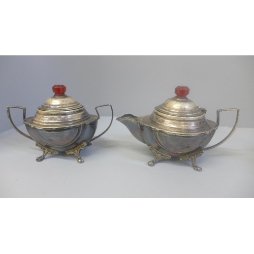 634 - A plated three piece tea service with red Bakelite or phenolic finials and handle