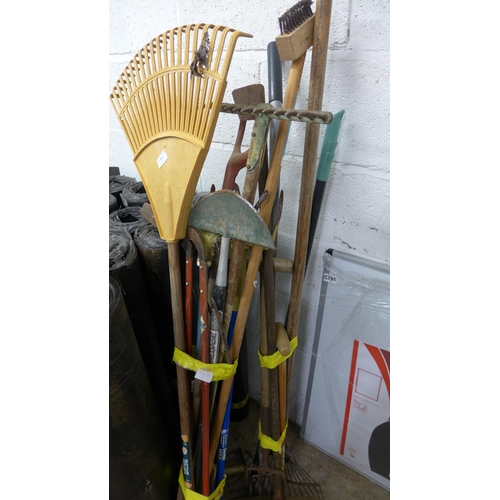 2480 - Two bundles of mixed garden tools: rakes, forks, wire brush, lawn edger, etc.