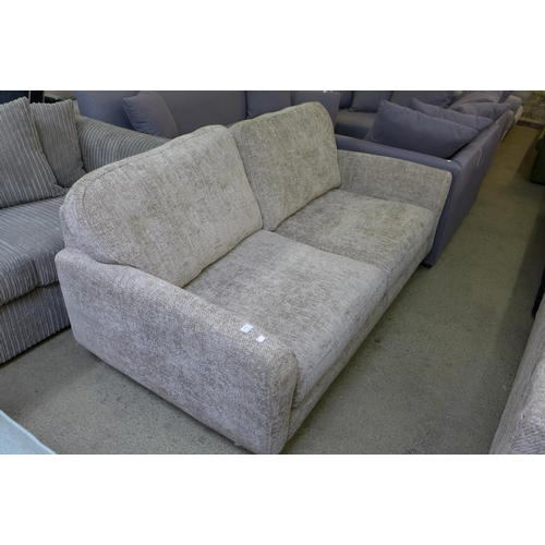 1610 - An oatmeal upholstered convertible three seater sofa/chaise