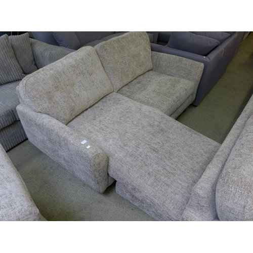 1610 - An oatmeal upholstered convertible three seater sofa/chaise