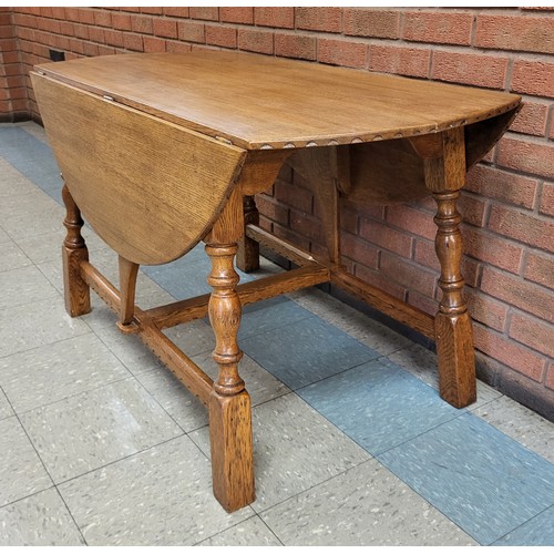 102A - A Nigel Griffiths carved oak drop-leaf table