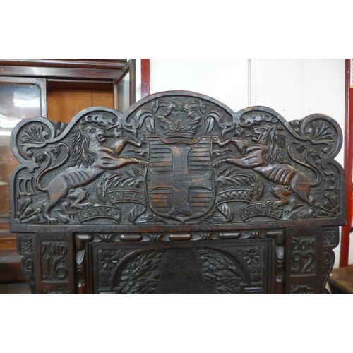 110 - A 17th Century style oak Wainsot chair, with extensive commemorative carving of William III victory ... 