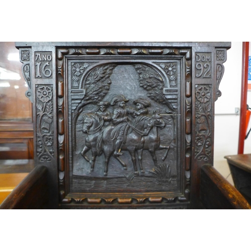 110 - A 17th Century style oak Wainsot chair, with extensive commemorative carving of William III victory ... 