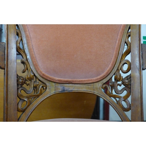 112 - A French Art Nouveau carved walnut and peach fabric upholstered revolving armchair