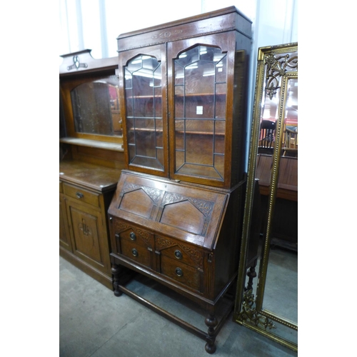 142 - An early 20th Century carved oak bureau bookcase