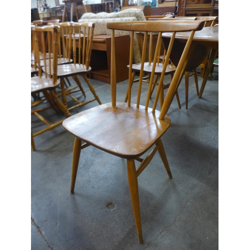 60 - An Ercol Blonde elm and beech drop leaf table and a set of four 737 model chairs