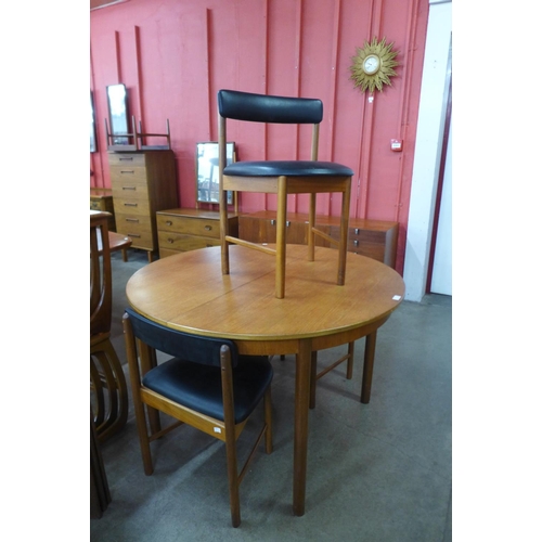 7 - A McIntosh teak circular extending dining table and four chairs