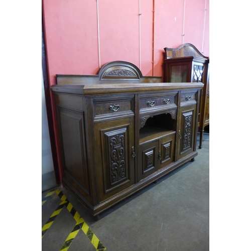 96 - An Arts and Crafts carved oak sideboard