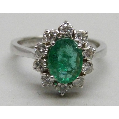 1061 - An 18ct white gold, emerald and diamond cluster ring, 4.5g, M, emerald approximately 6 x 8mm