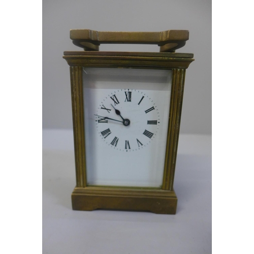 655 - A brass cased and four glass sided carriage clock with key