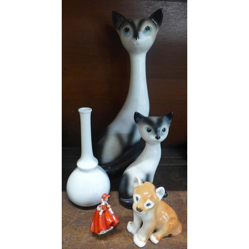 676 - Two Sylvac long neck cats, large and small, a USSR lion cub, a Royal Doulton figure, boxed and a Roy... 