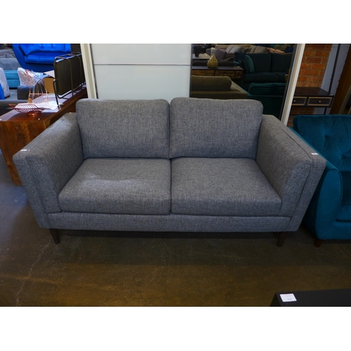 1560 - A stone grey upholstered three seater sofa