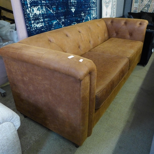 1601 - A tan faux leather button back Chesterfield style three seater sofa