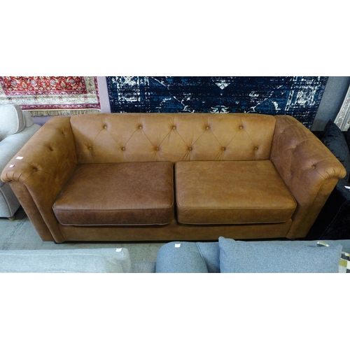 1601 - A tan faux leather button back Chesterfield style three seater sofa