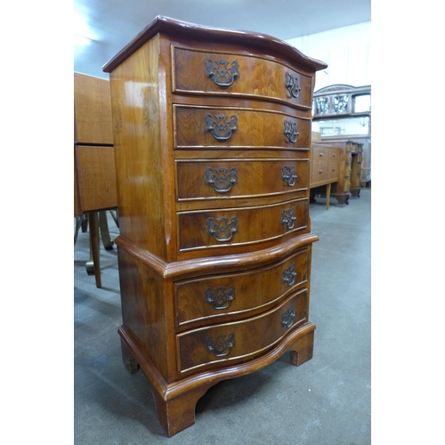 128 - A small yew wood serpentine chest of drawers