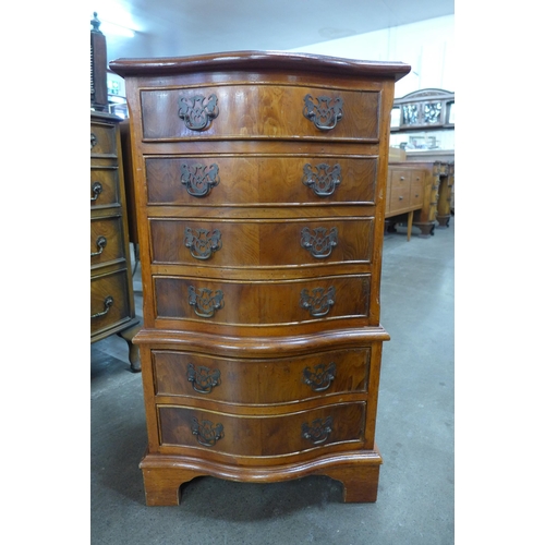 128 - A small yew wood serpentine chest of drawers