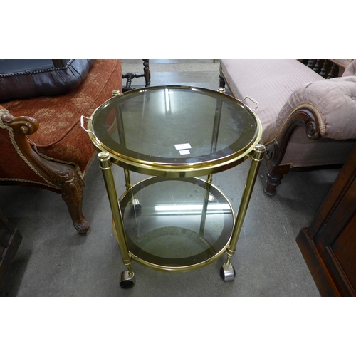 140 - An Italian style circular brass and glass two tier cocktail trolley