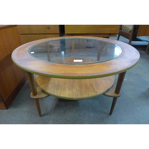 33 - A circular teak and and glass topped coffee table