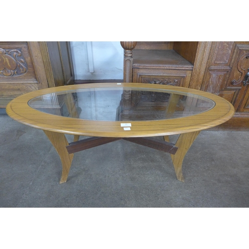 61 - An oval teak and glass topped coffee table