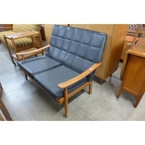 64 - A teak and black vinyl settee