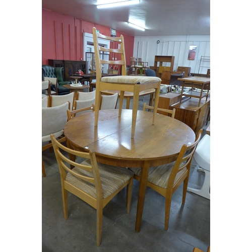 69 - A circular teak extending dining table and five chairs