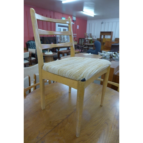 69 - A circular teak extending dining table and five chairs