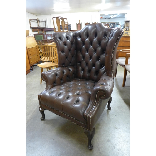 92 - A Chesterfield chestnut brown leather wingback armchair