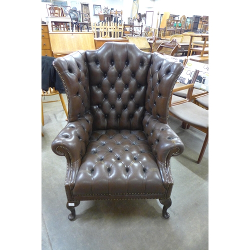 92 - A Chesterfield chestnut brown leather wingback armchair