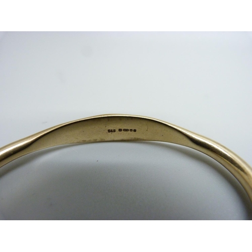 1003 - A 9ct gold bangle, 21.5g, back opening 32mm