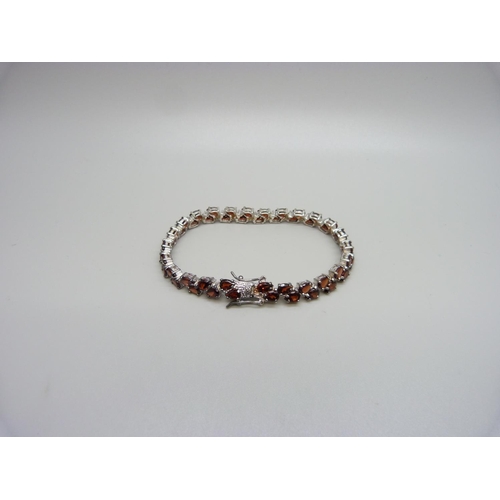 1124 - A silver and garnet bracelet