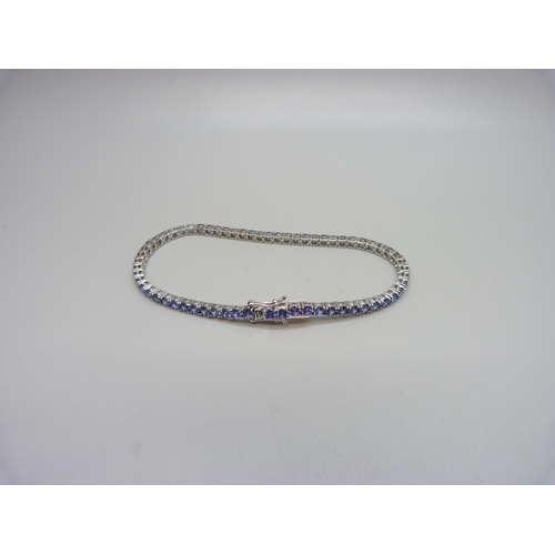 1127 - A silver and tanzanite tennis bracelet