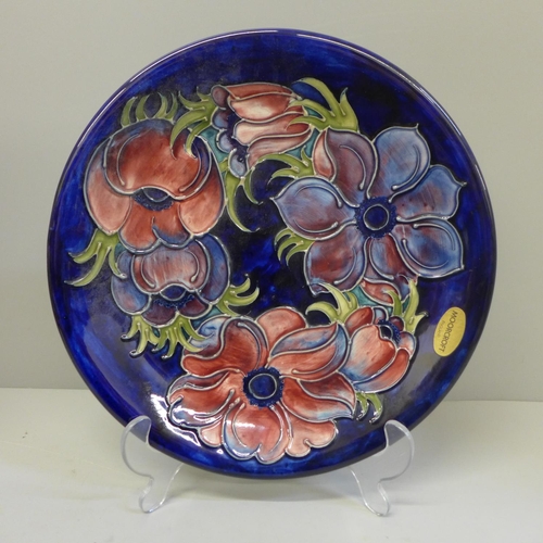 611 - A Moorcroft anemone charger, 25.5cm and display stand