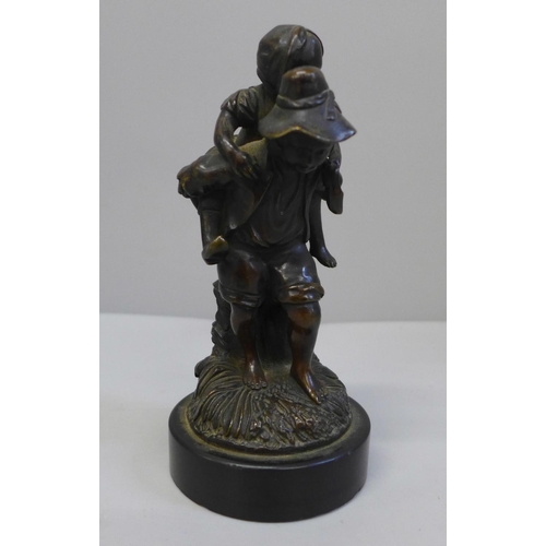 677 - A Dutch bronze figure group of a boy giving a piggy-back to a young girl, 15cm