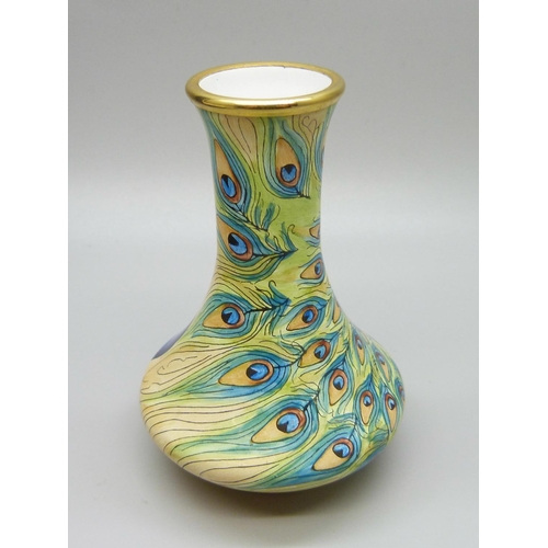 880 - A Moorcroft peacock pattern enamel miniature vase