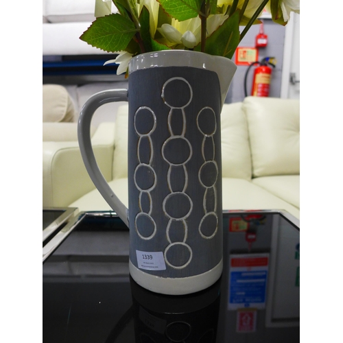 1339 - A large grey ceramic Emilie jug with circle print decoration and artificial flowers  H26cms (7HM2231... 