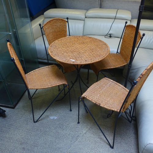 1646 - A wicker style round table with four chairs, a metal coat stand and a brown rug