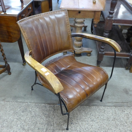 199 - A black metal, hardwood and brown leather armchair