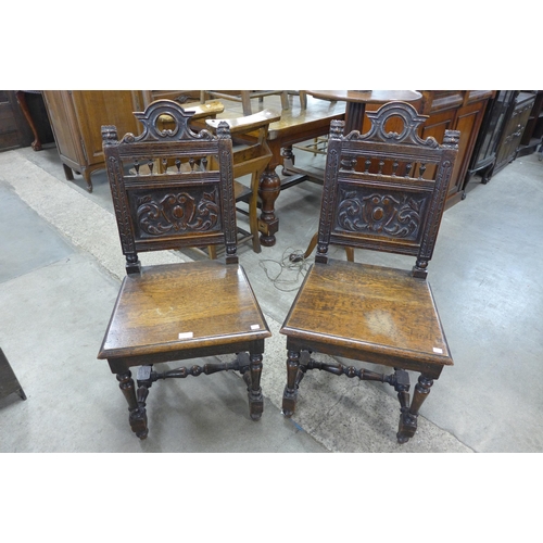 135 - A pair of Victorian Jacobean Revival carved oak hall chairs