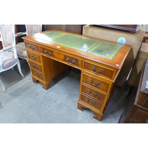 139 - A yew wood and green leather topped pedestal desk