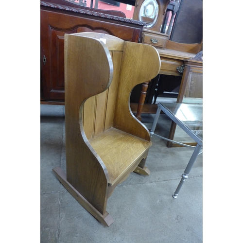 178 - A Cotswold style oak childs rocking chair