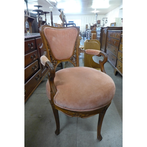 179 - A French Art Nouveau carved walnut and peach fabric upholstered revolving armchair