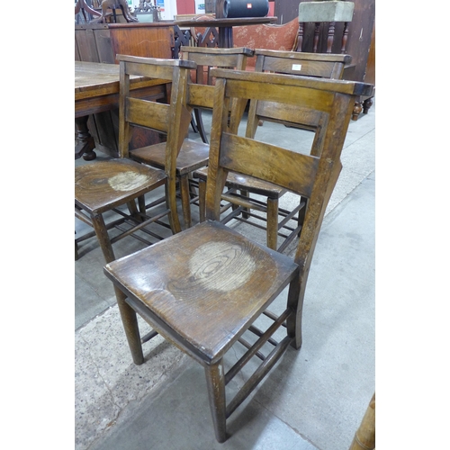 183 - A set of four early 20th Century elm and beech chapel chairs