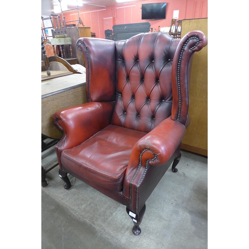 188 - An oxblood red leather wingback armchair, a/f