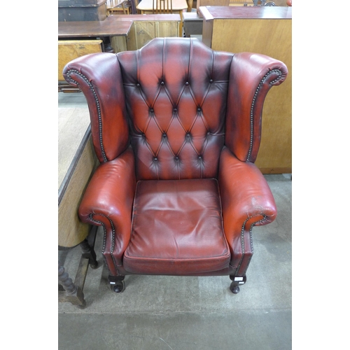 188 - An oxblood red leather wingback armchair, a/f