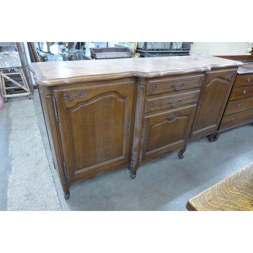 215 - A large French carved oak breakfront sideboard