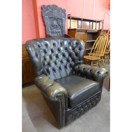 26 - A green leather Chesterfield wingback armchair