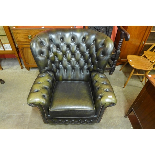 26 - A green leather Chesterfield wingback armchair