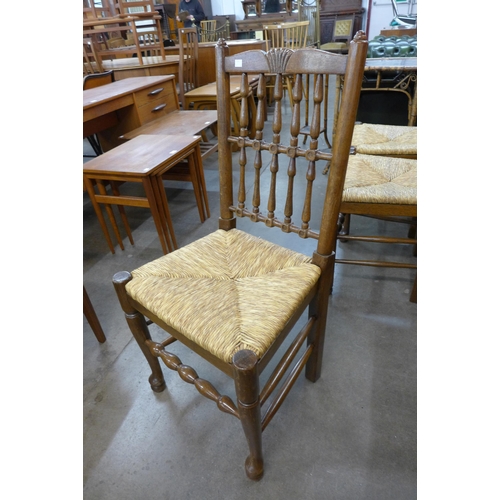 29 - A set of six George III style elm and rush seated spindle back chairs